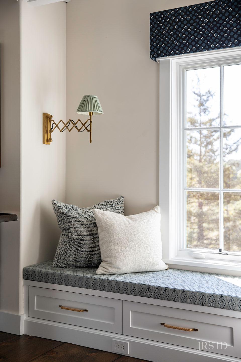 Built-in window seat with custom cushion, brass accordion sconce, and scenic views in Montecito California home