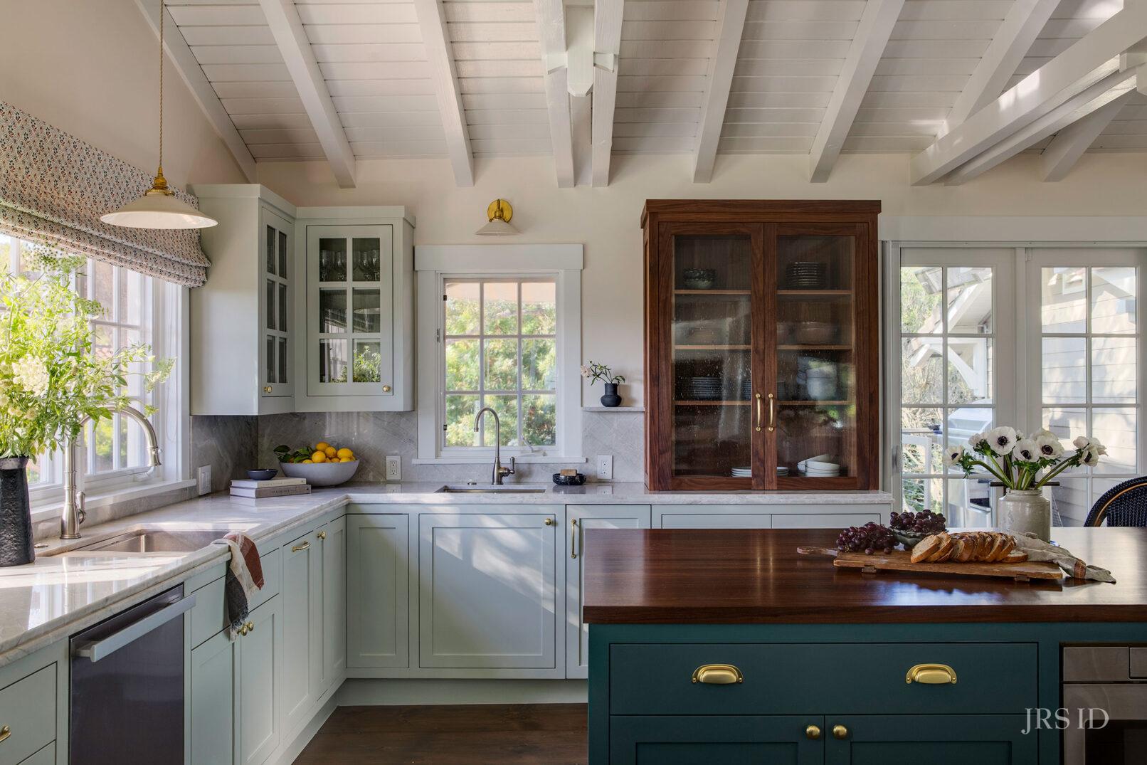 Custom Montecito kitchen with painted cabinetry, walnut storage cabinet, marble countertops, and Santa Barbara interior design