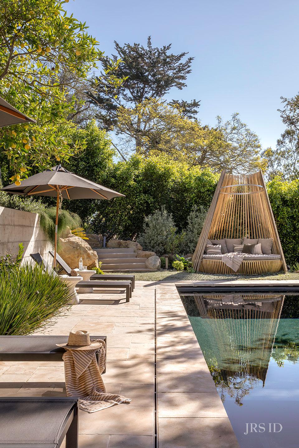 Poolside lounge area surrounded by mature landscaping at the Eucalyptus Hill ADU Residence in Montecito.