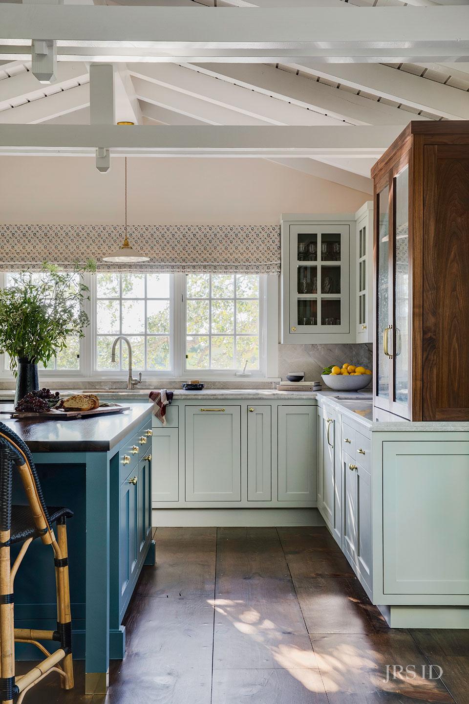 Montecito kitchen featuring blue island cabinetry, brass hardware, marble surfaces, and custom millwork by Santa Barbara designer