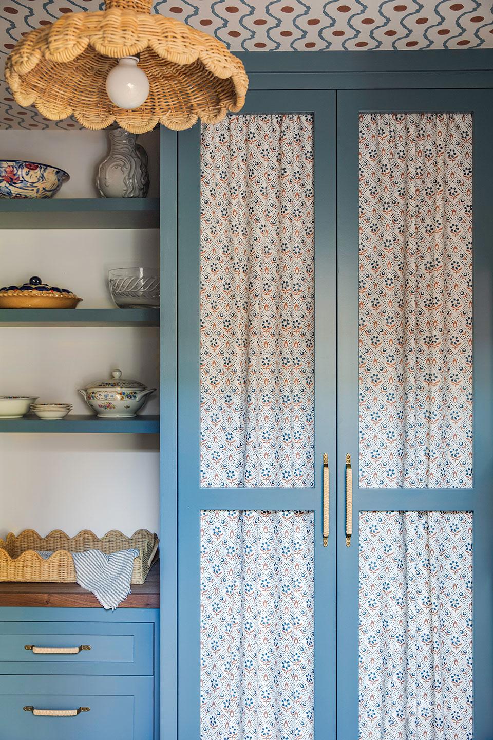 Montecito kitchen featuring blue island cabinetry, brass hardware, marble surfaces, and custom millwork by Santa Barbara designer
