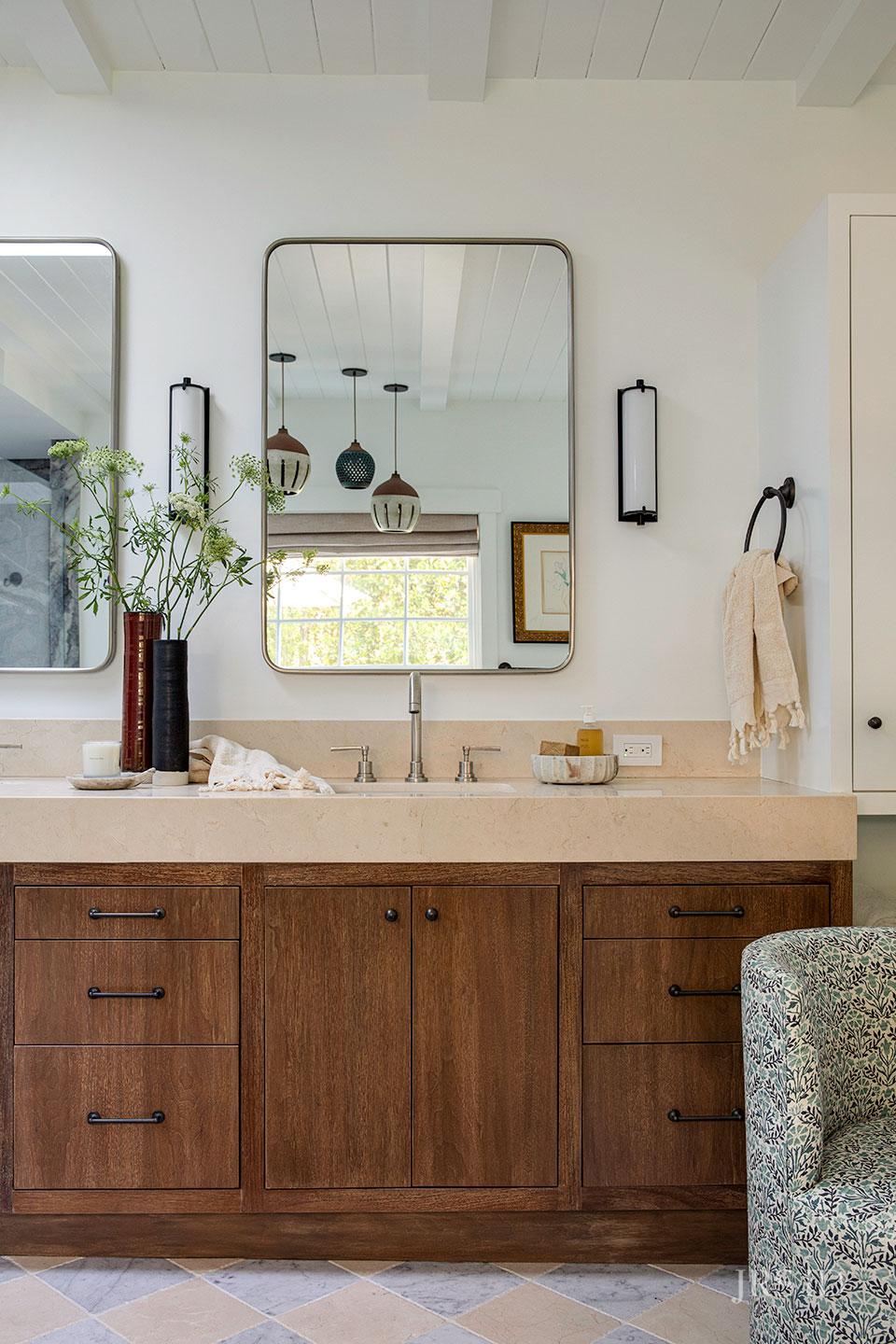 Custom walnut bathroom vanity with stone countertop, modern lighting, and Montecito interior design details